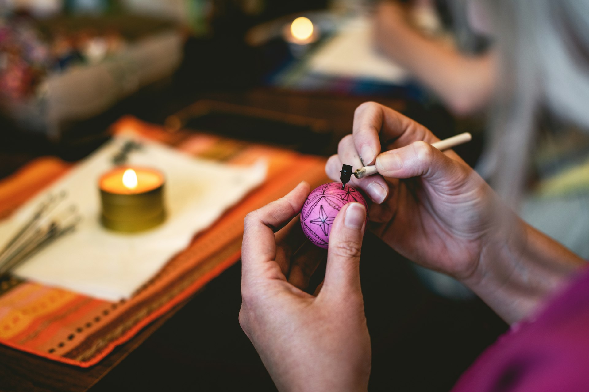 a woman is lighting a candle on a table
